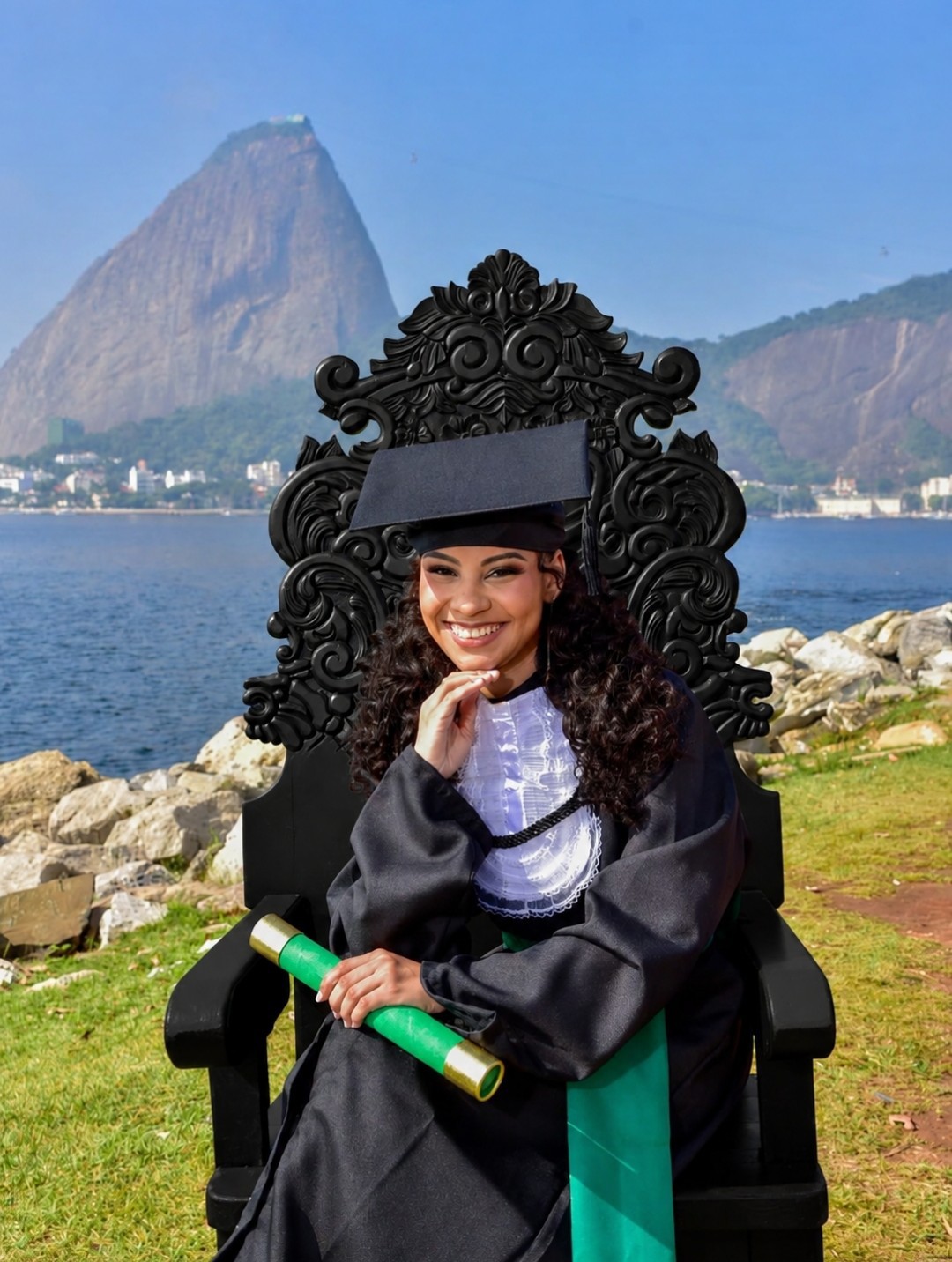 Formanda com beca na cadeira Luís XV durante ensaio fotográfico